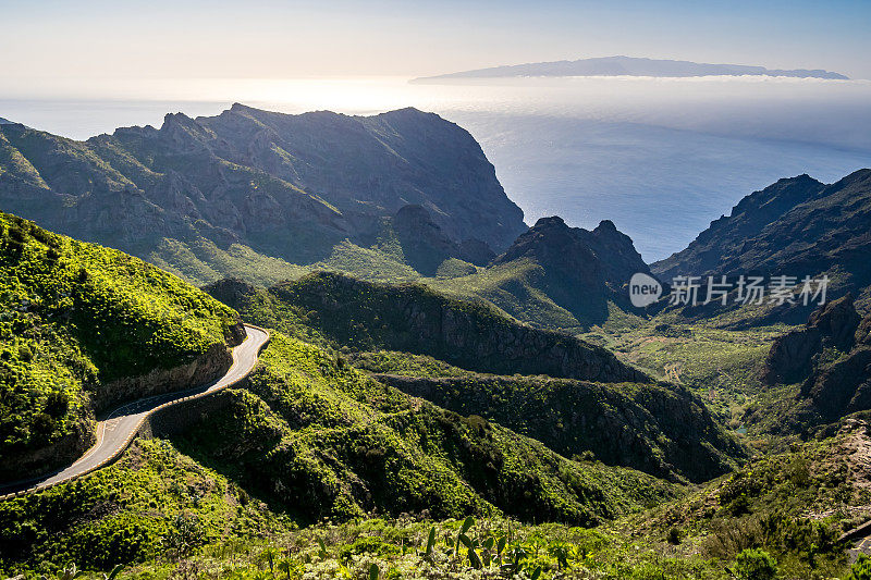 Stunning beauty of the Teno Mountains on the winding TF-436 road with its panoramic views of the Atlantic Ocean with La Gomera island, surrounded by lush greenery and bathed in the warm sunlight.